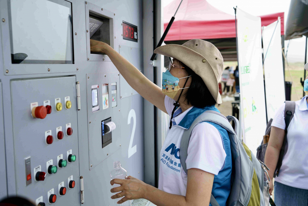 志工們將拾起的寶特瓶投入「好歸塑專車」，讓廢棄塑料空瓶可以直接粉碎、縮小體積，未來將可再製成購物袋、寶特衣、悠遊卡等生活用品
